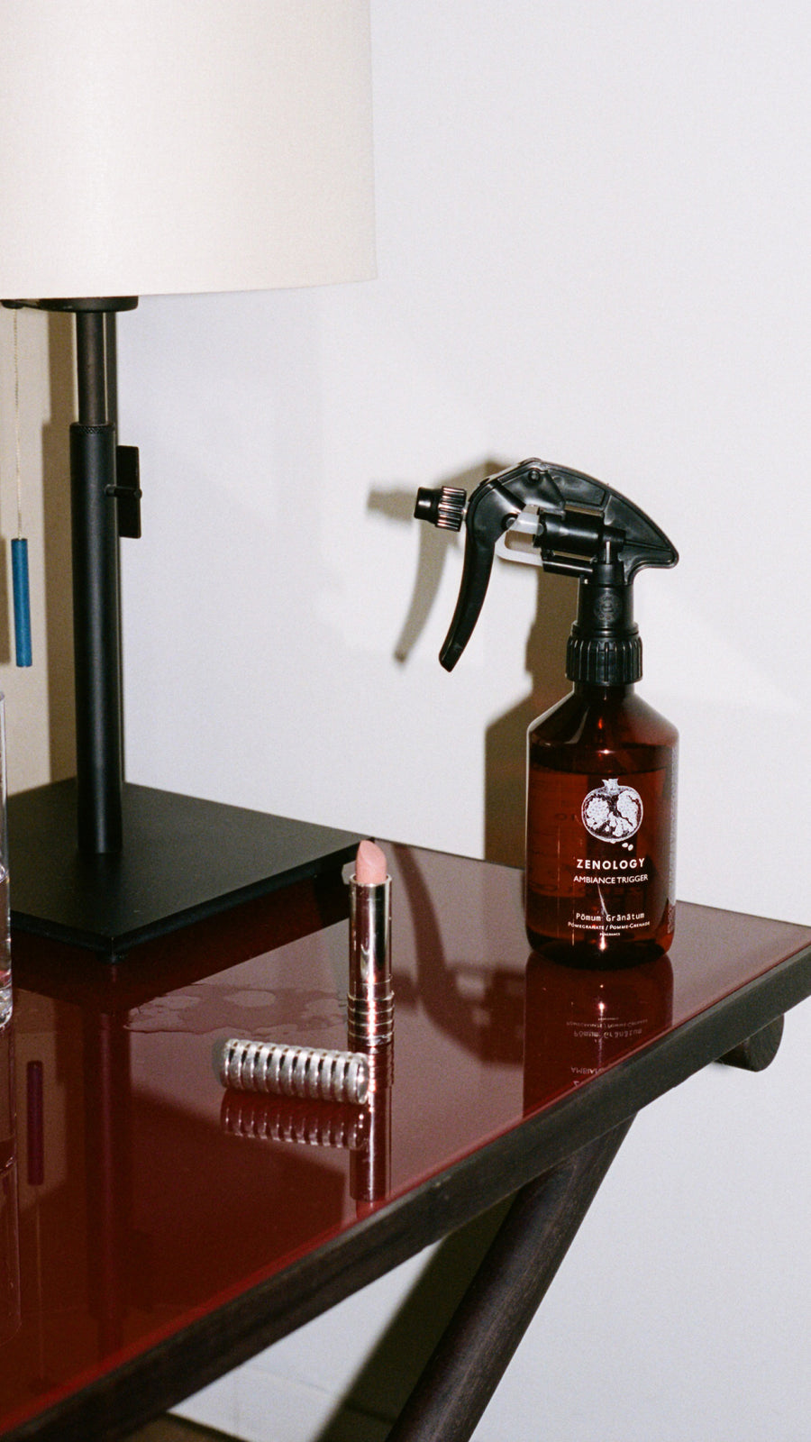 A black lamp stand and a brown spray bottle labeled