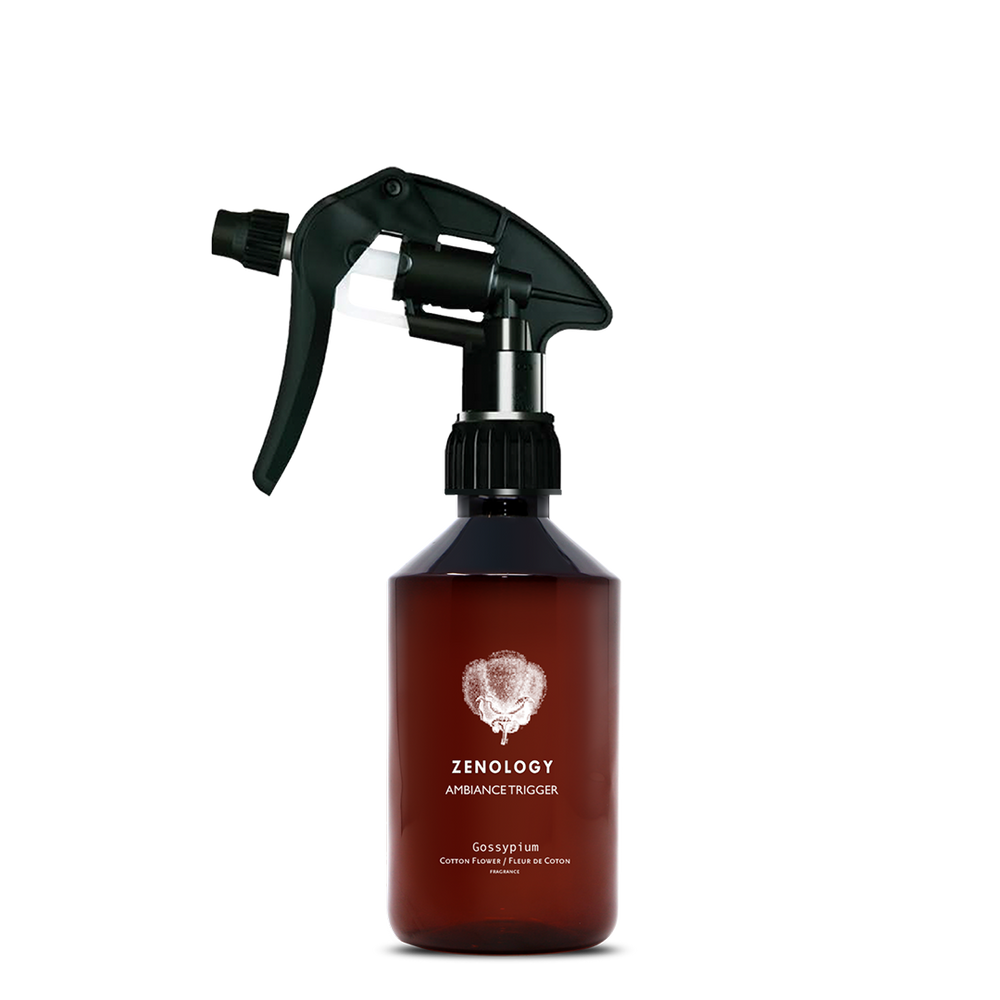 A mid sized brown spray bottle labeled Zenology Ambiance Trigger Gossypium featuring an unique botanical illustration with a black spray nozzle.