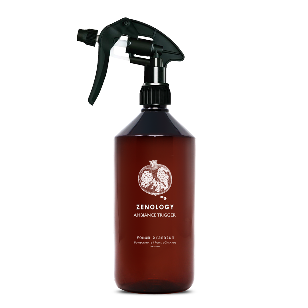 A large sized brown spray bottle labeled Zenology Ambiance Trigger Pōmum Grānātum featuring an unique botanical illustration with a black spray nozzle.