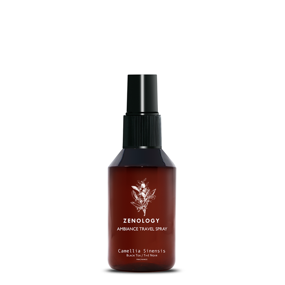 A small sized brown spray bottle labeled Zenology Ambiance Travel Spray Camellia Sinensis featuring an unique botanical illustration with a black spray top.