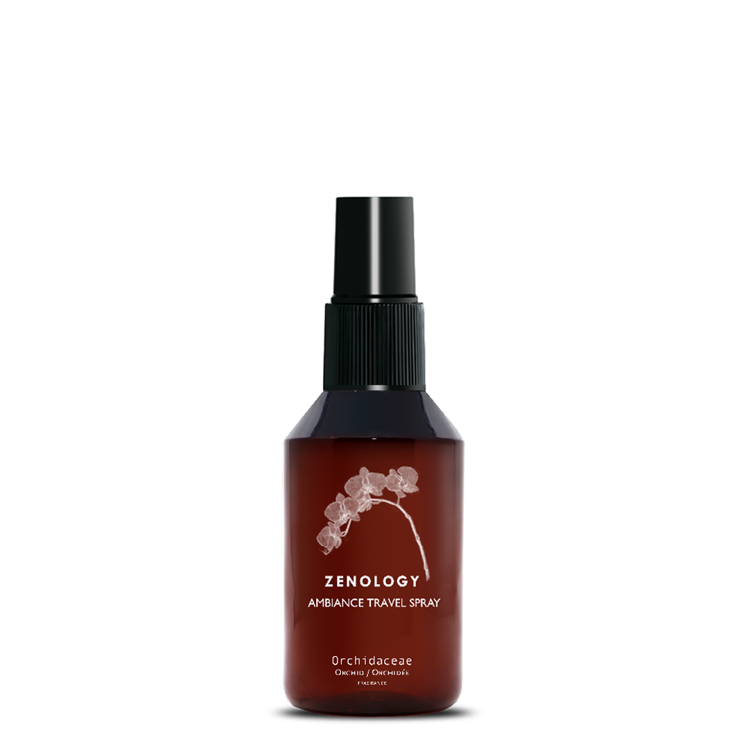 A small sized brown spray bottle labeled Zenology Ambiance Travel Spray Orchidaceae featuring an unique botanical illustration with a black spray top.