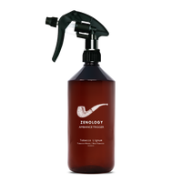 A large sized brown spray bottle labeled Zenology Ambiance Trigger Tobacco Lignum featuring an unique botanical illustration with a black spray nozzle.