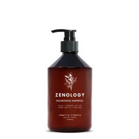 A brown pump bottle labeled Zenology Nourishing Shampoo Camellia Sinensis featuring an unique botanical illustration and a black pump.