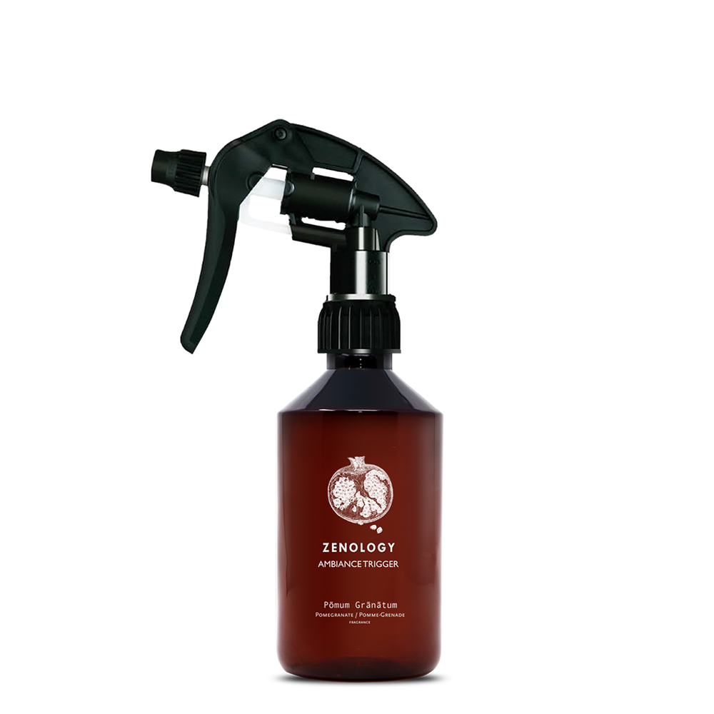 A mid sized brown spray bottle labeled Zenology Ambiance Trigger Pōmum Grānātum featuring an unique botanical illustration with a black spray nozzle.