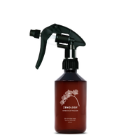A mid sized brown spray bottle labeled Zenology Ambiance Trigger Orchidaceae featuring an unique botanical illustration with a black spray nozzle.