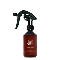 A mid sized brown spray bottle labeled Zenology Ambiance Trigger Citrus Nobilis featuring an unique botanical illustration with a black spray nozzle.
