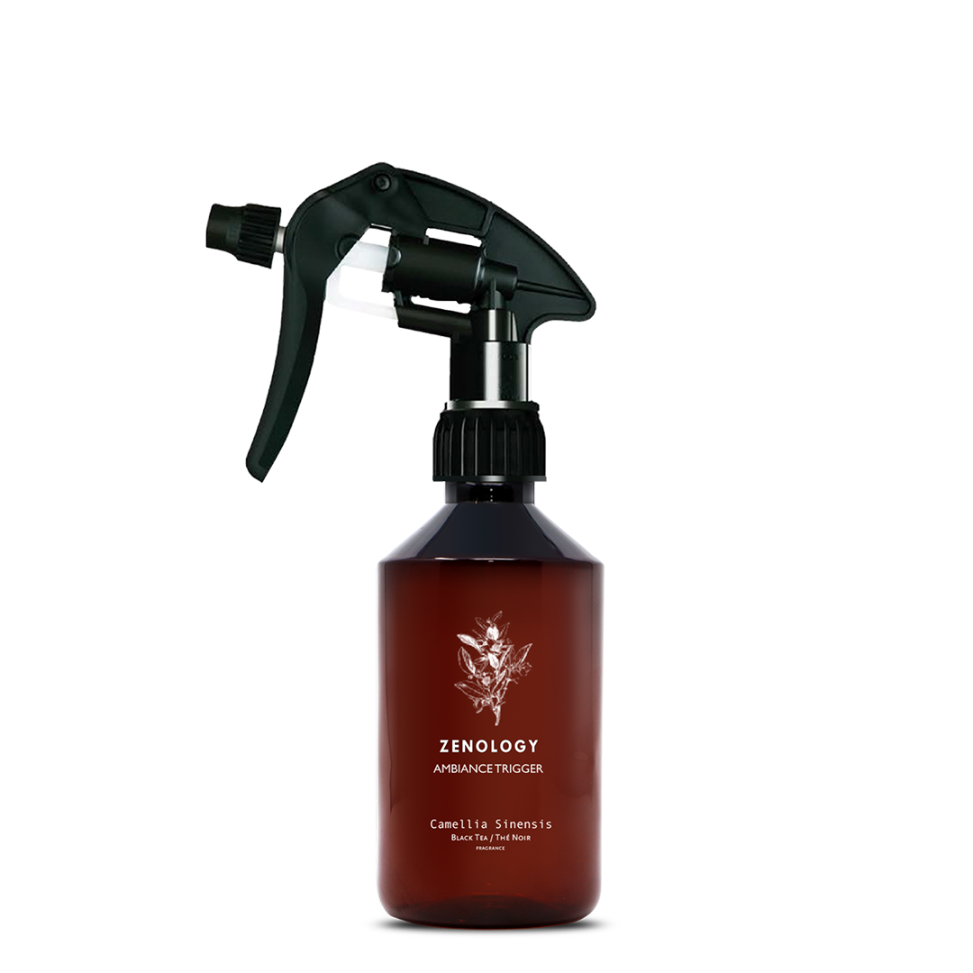 A mid sized brown spray bottle labeled Zenology Ambiance Trigger Camellia Sinensis featuring an unique botanical illustration with a black spray nozzle.