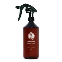A large sized brown spray bottle labeled Zenology Ambiance Trigger Pōmum Grānātum featuring an unique botanical illustration with a black spray nozzle.