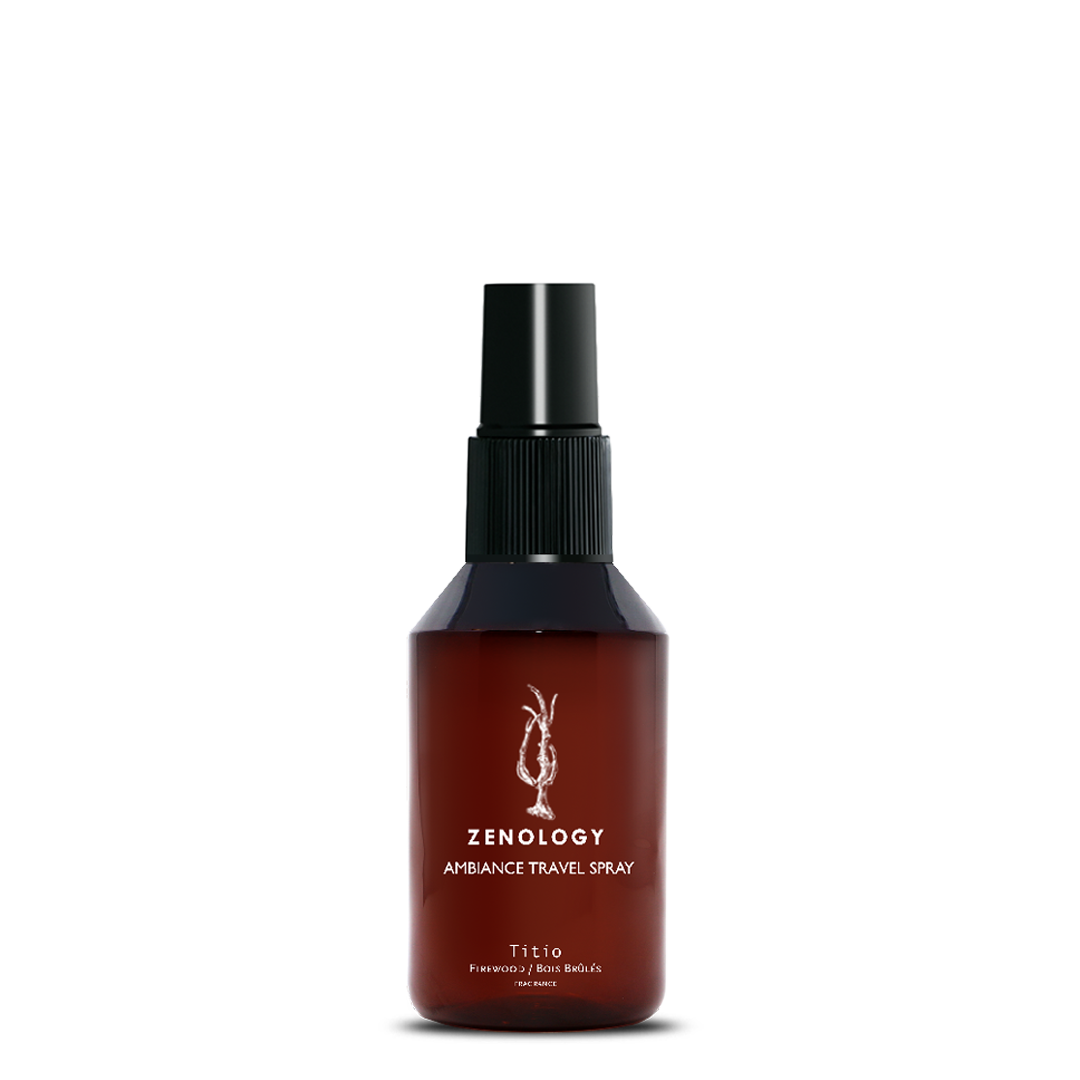 A small sized brown spray bottle labeled Zenology Ambiance Travel Spray Titio featuring an unique botanical illustration with a black spray top.
