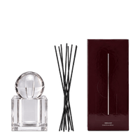 Crystal perfume diffuser gift box with crystal bottle and sphere arranged beside it on a dark teal background.